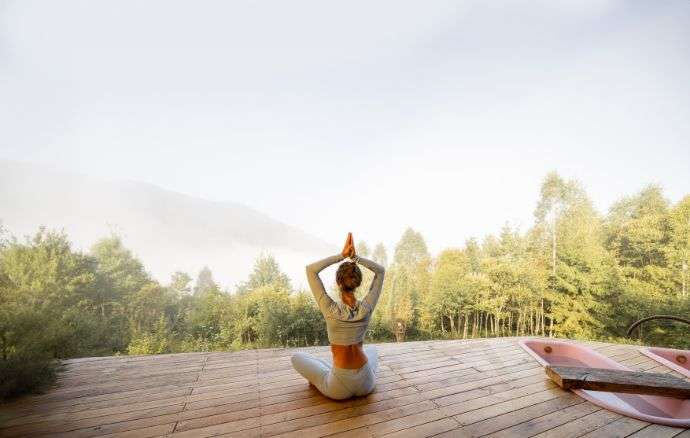 ospite hotel che svolge attività yoga meditazione in ambiente rilassante n montagna